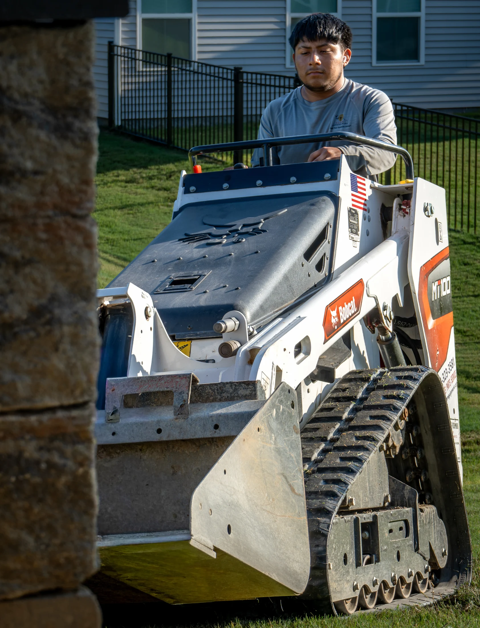 A Sunny crew member operating a compact loader