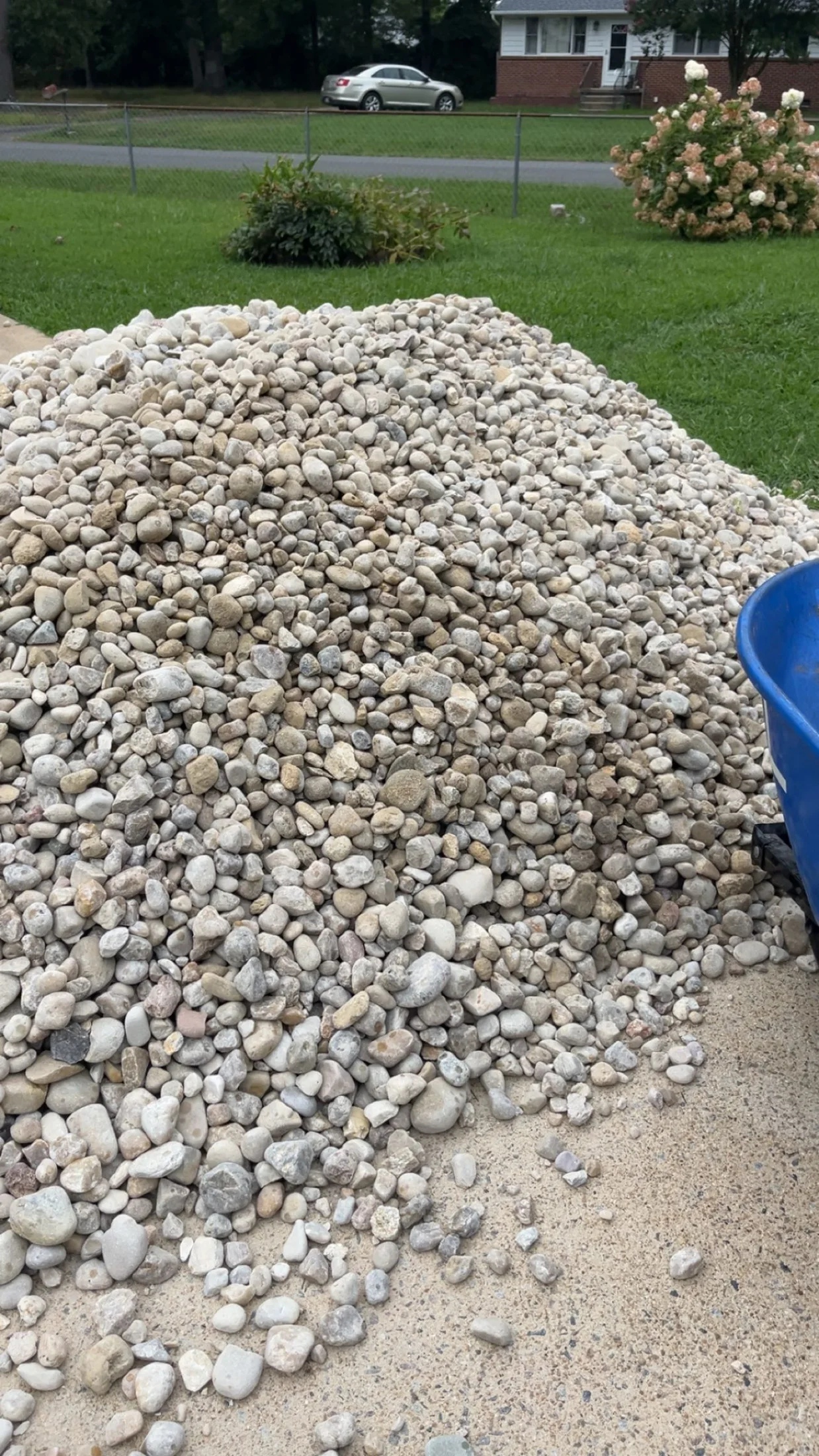 Decorative river rock delivered beside a front lawn