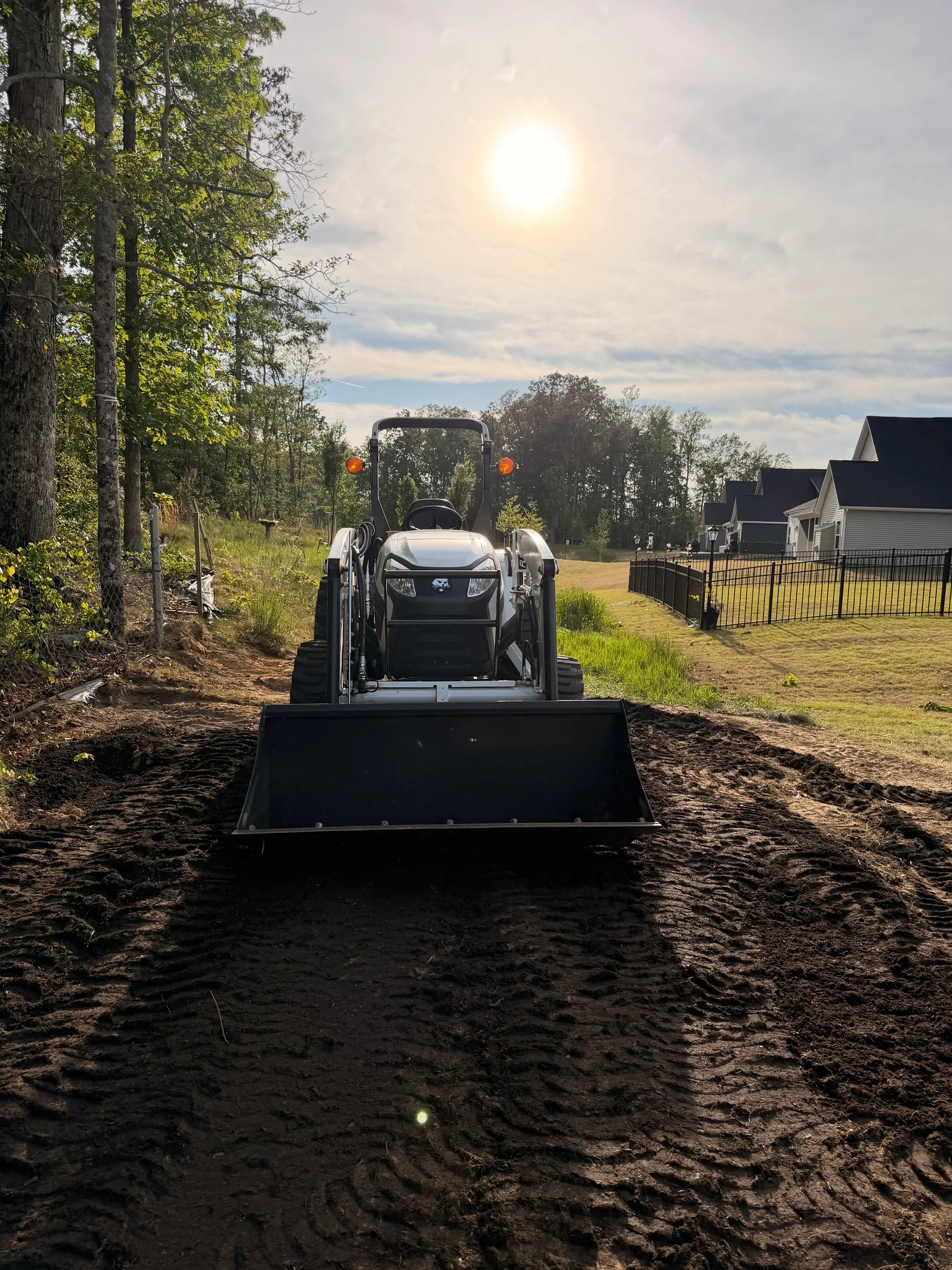 Compact tractor and bucket on recently worked soil