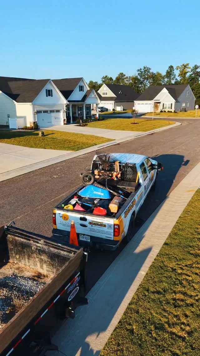 Sunny Landscaping truck and equipment beside newly worked residential lawns