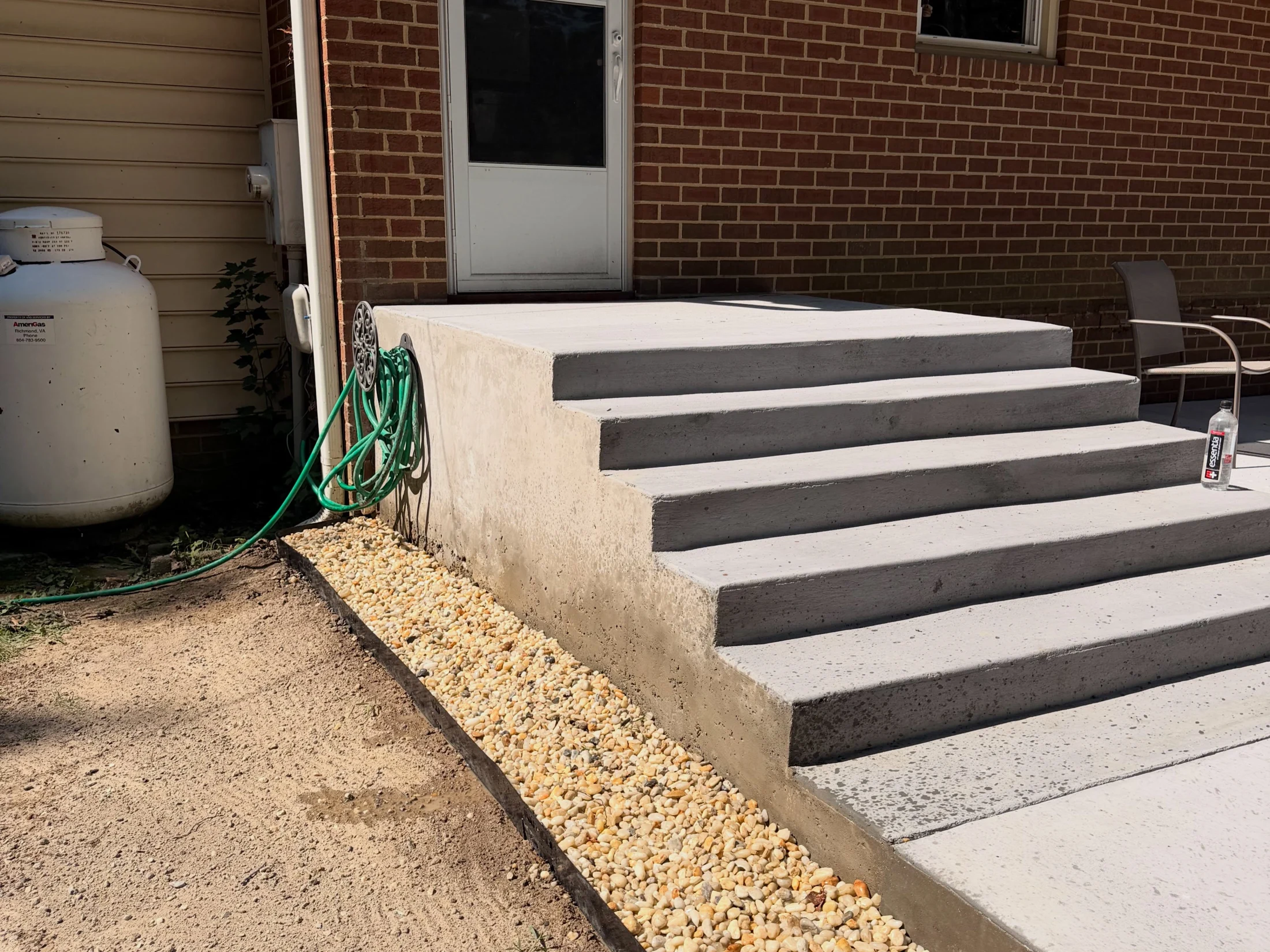 Close view of concrete patio steps and the adjoining decorative gravel border