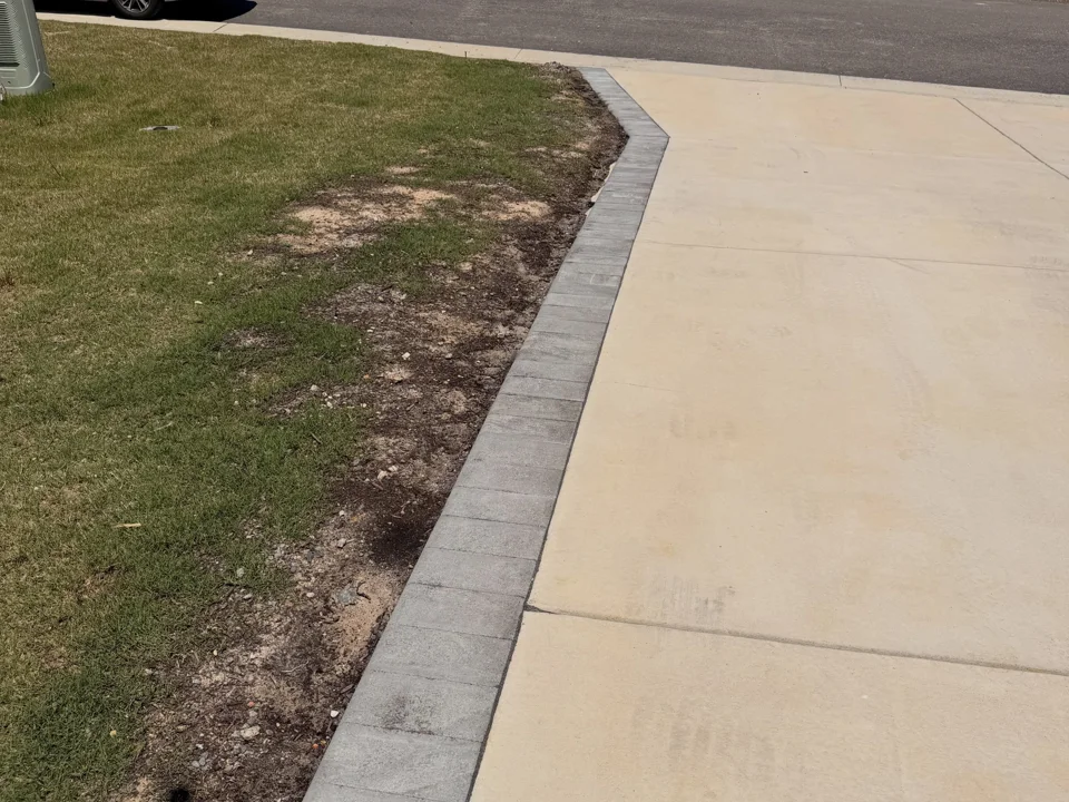 Gray block border following the curve of a concrete driveway
