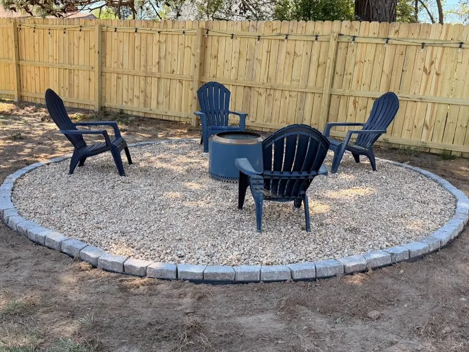 Circular gravel firepit area with Adirondack chairs and a block border