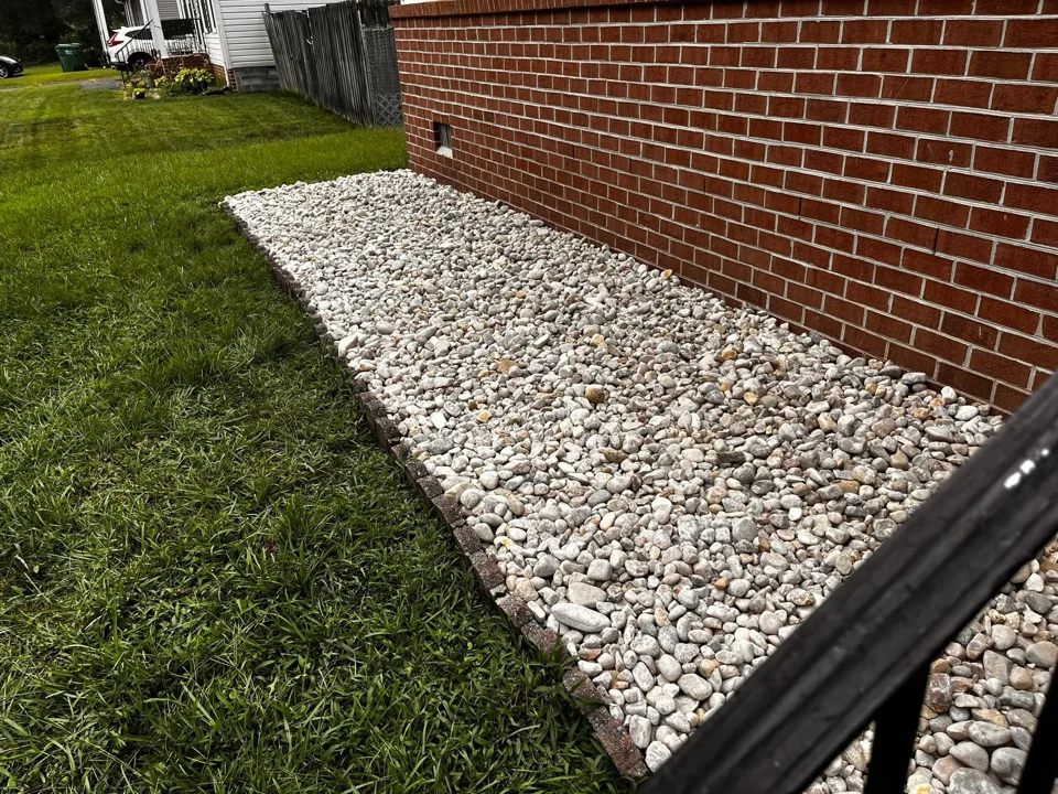 White decorative stone beside a brick house and brick edging