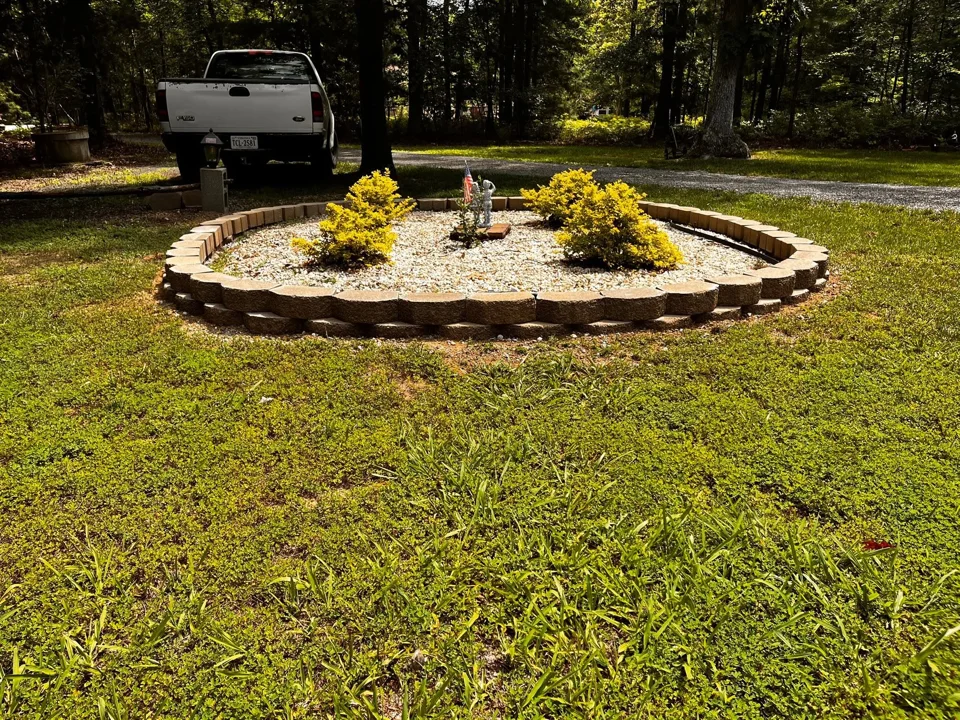 Round planting island with stacked landscape blocks and pale decorative stone